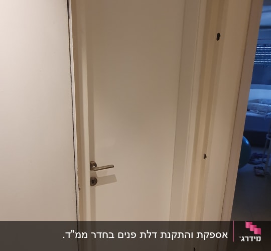 דלת לבנה עם ידית מתכת, פתוחה חלקית